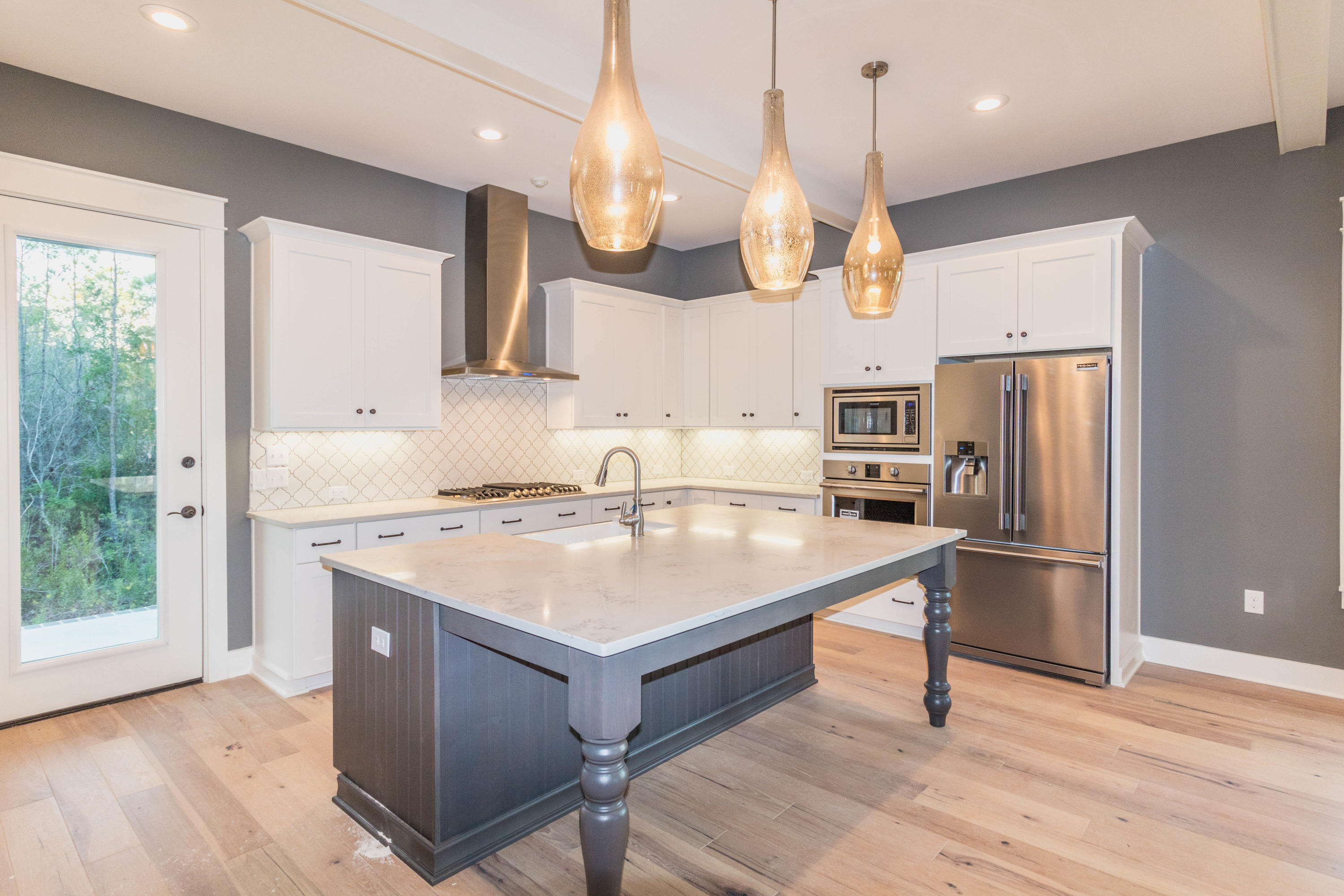 228 Ridgewalk Circle Santa Rosa Beach, FL 32459 - Photo 2 of 21 a kitchen with a refrigerator a sink dishwasher a oven with a dining table and chairs