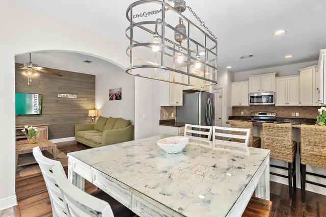 a kitchen with stainless steel appliances kitchen island granite countertop a table and chairs in it