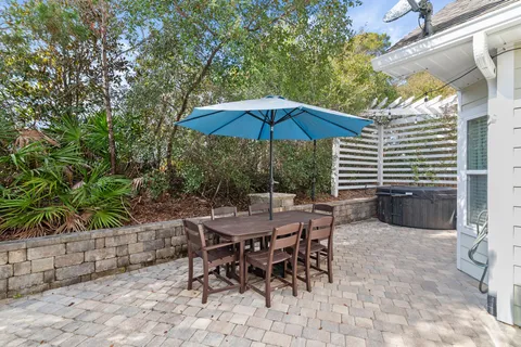 a view of a patio with a table and chairs under an umbrella