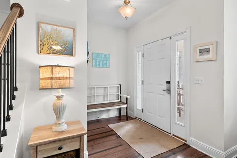 a hallway with a couch and a potted plant next to a window