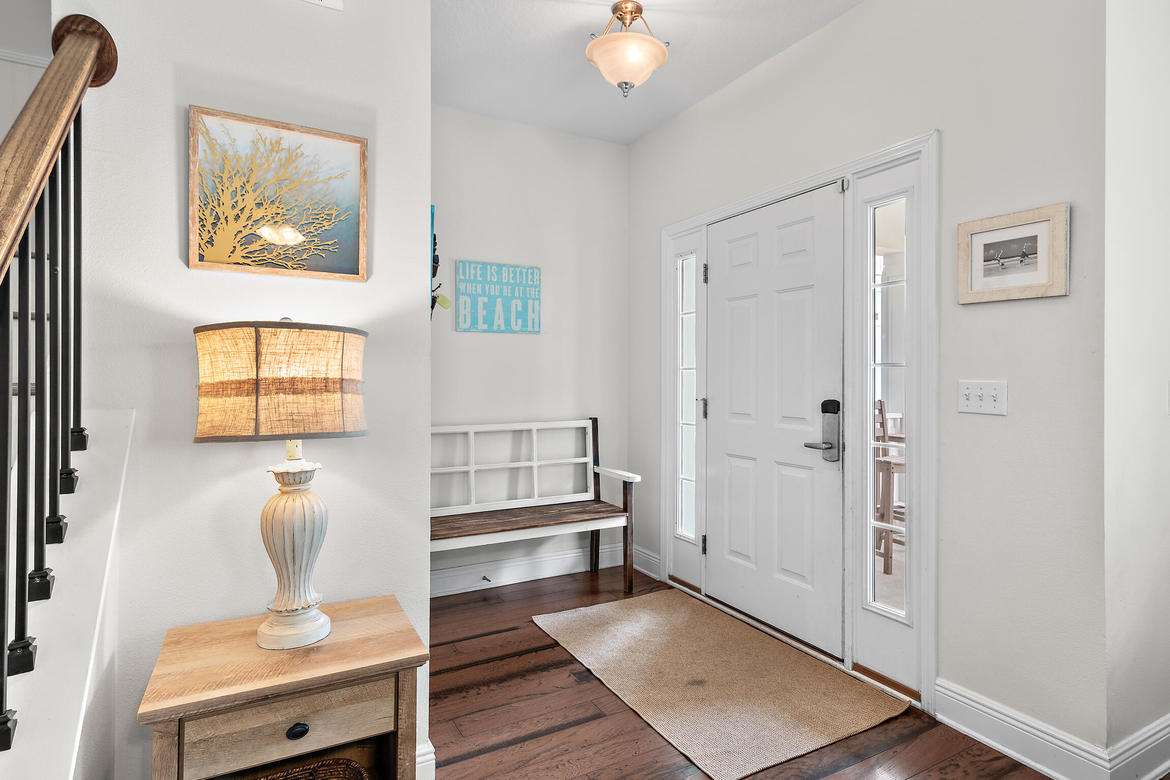 19 Charming Way Santa Rosa Beach, FL 32459 - Photo 3 of 52 a hallway with a couch and a potted plant next to a window