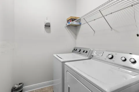 a view of a white house with large windows and a small yard