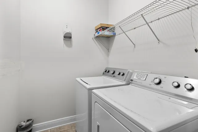 a view of a white house with large windows and a small yard