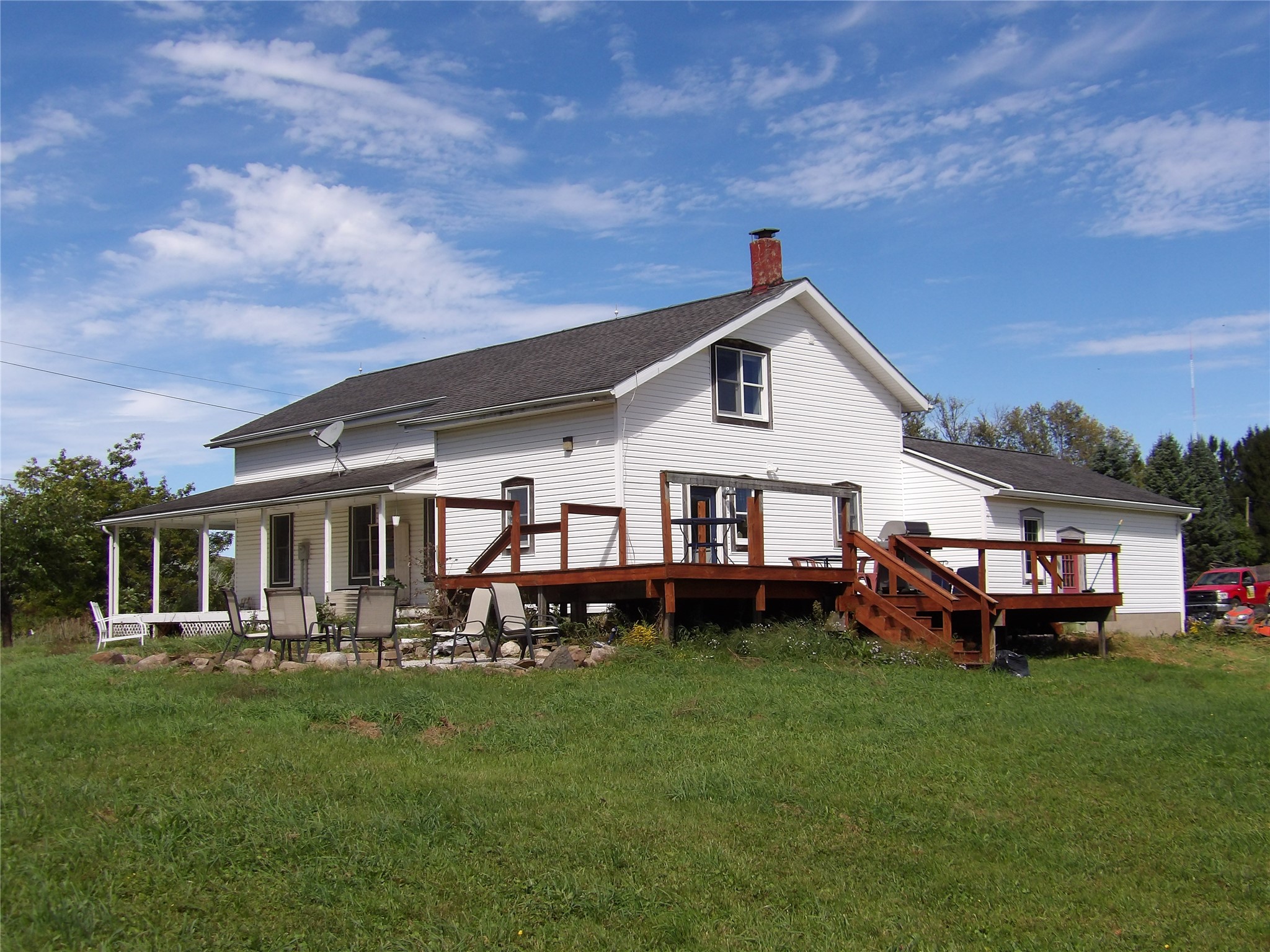 1345 Donation Road Erie, PA 16509 - Photo 45 of 47 Rear corner view of home with deck and wrap-around porch. The fire pit was once a pool area and has electric service run for a pump.