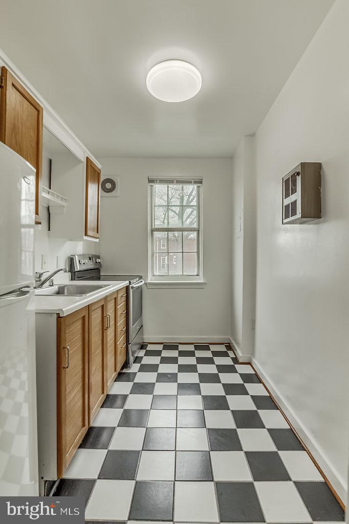 3311 Commonwealth Avenue, Unit E Alexandria, VA 22305 - Photo 12 of 31 a kitchen with a checkered floor and white cabinets