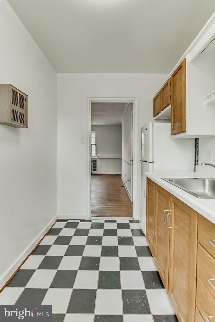 3311 Commonwealth Avenue, Unit E Alexandria, VA 22305 - Photo 14 of 31 a kitchen with a checkered floor and white cabinets