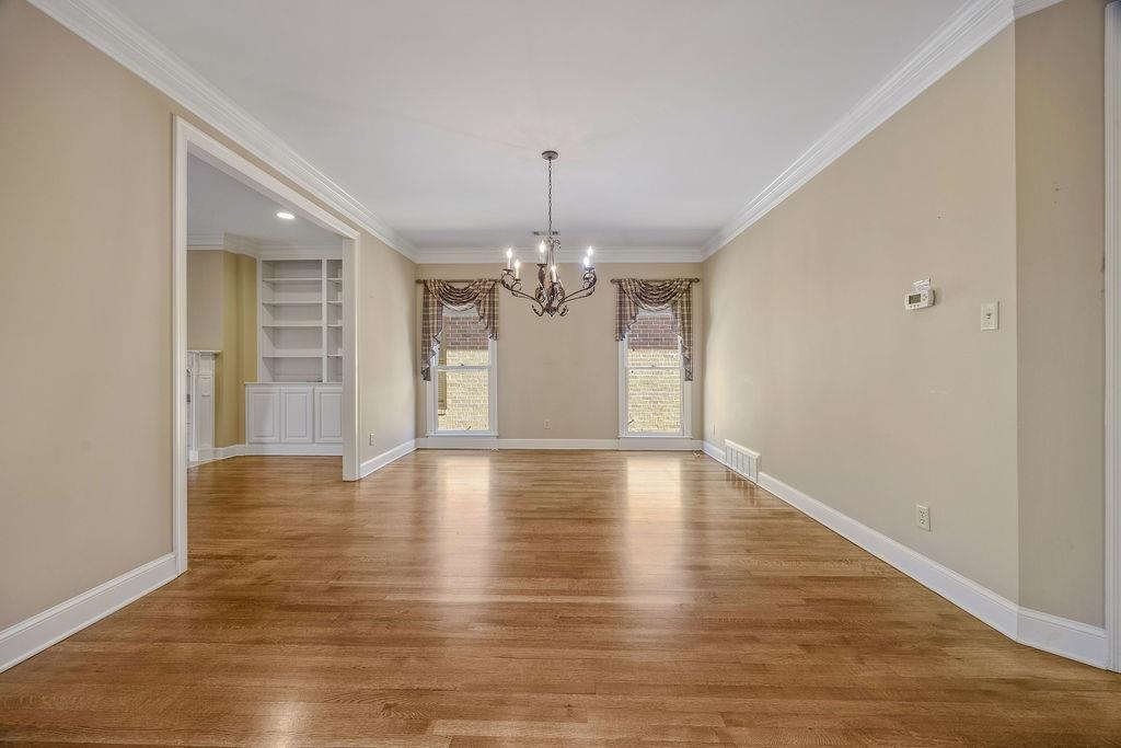 8009 Fox Fern Road Germantown, TN 38138 - Photo 12 of 40 a view of an empty room with wooden floor and chandelier