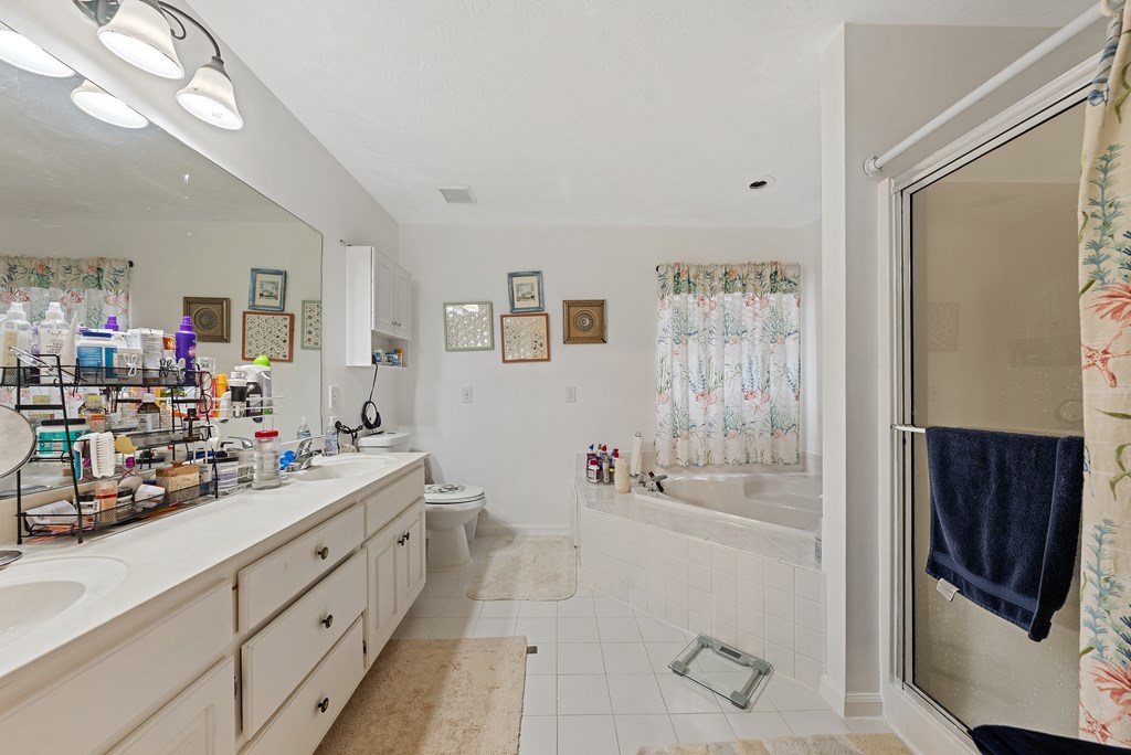 370 Evergreen Drive Fortson, GA 31808 - Photo 16 of 32 a bathroom with a double vanity sink a mirror and shower