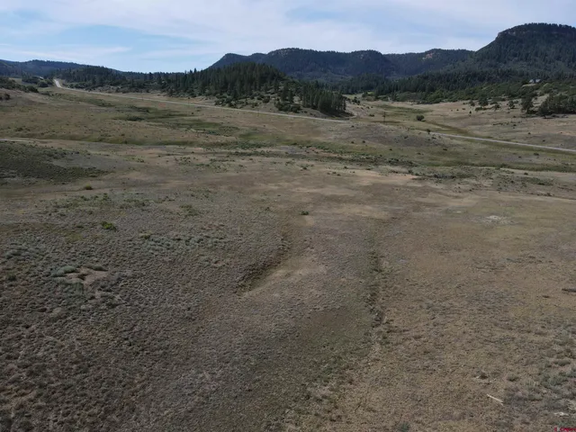 a view of mountains with green field and mountains