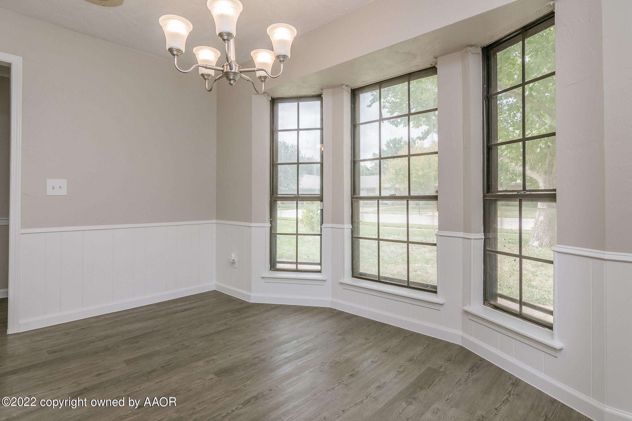 7720 Canode Drive Amarillo, TX 79121 - Photo 3 of 21 an empty room with wooden floor fan and windows