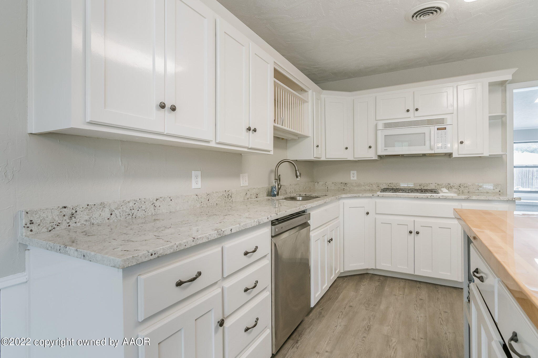 7720 Canode Drive Amarillo, TX 79121 - Photo 5 of 21 a kitchen with granite countertop white cabinets white stainless steel appliances and a sink
