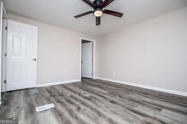 an empty room with a window and a ceiling fan