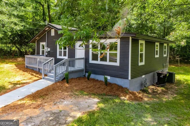 a view of a house with a yard and tree s