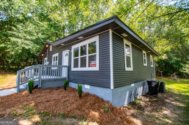 a view of wooden house with a small yard