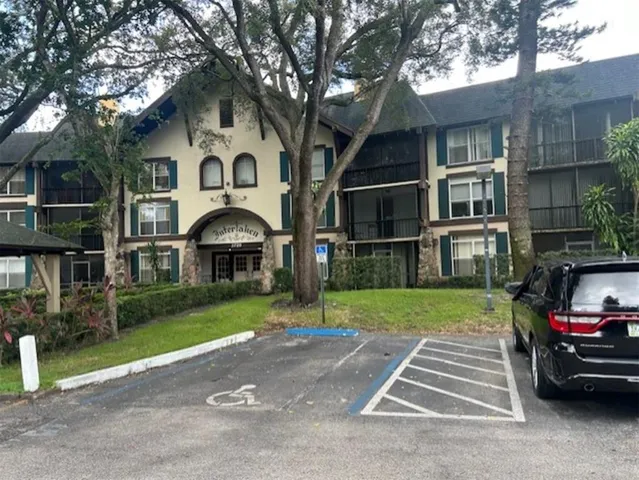 a front view of a house with a garden and trees