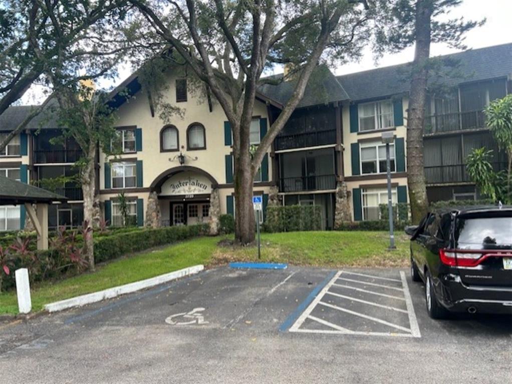 a front view of a house with a garden and trees