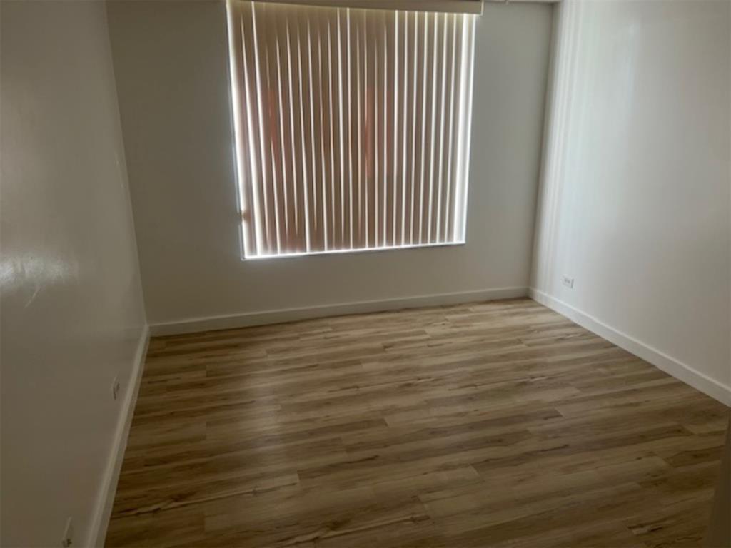 3720 Inverrary Drive, Unit 1T Lauderhill, FL 33319 - Photo 12 of 36 a view of an empty room with wooden floor and a window