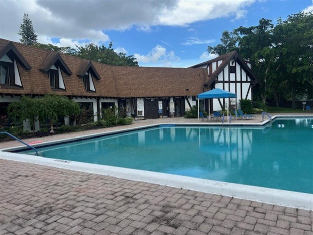 3720 Inverrary Drive, Unit 1T Lauderhill, FL 33319 - Photo 26 of 36 a view of a house next to a lake with a big yard