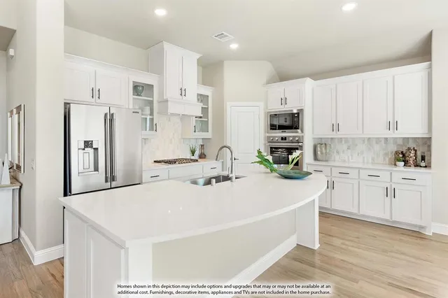 a view of kitchen with stainless steel appliances kitchen island refrigerator stove and kitchen island
