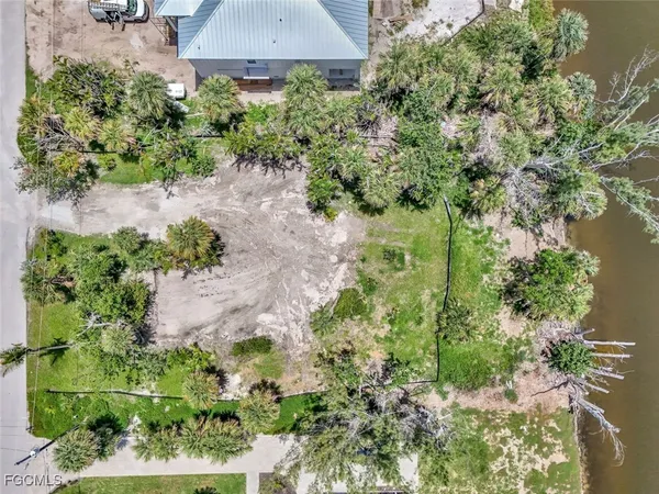 an aerial view of a house with a yard and garden in back
