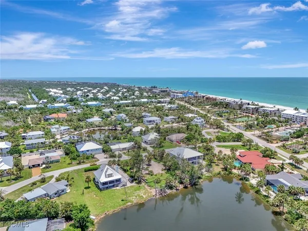 an aerial view of residential houses with outdoor space and ocean view