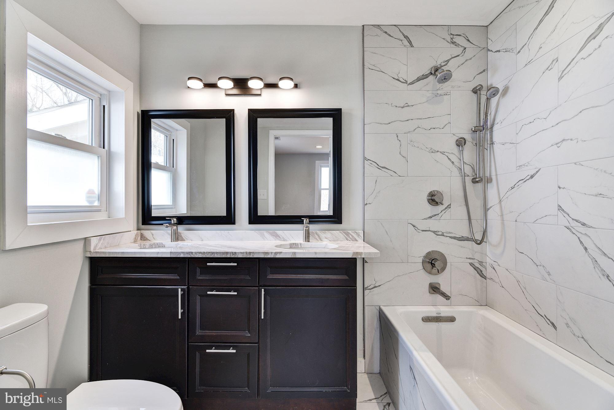 4303 Ivy Glen Road Silver Spring, MD 20906 - Photo 14 of 30 a bathroom with a granite countertop sink mirror and a bathtub