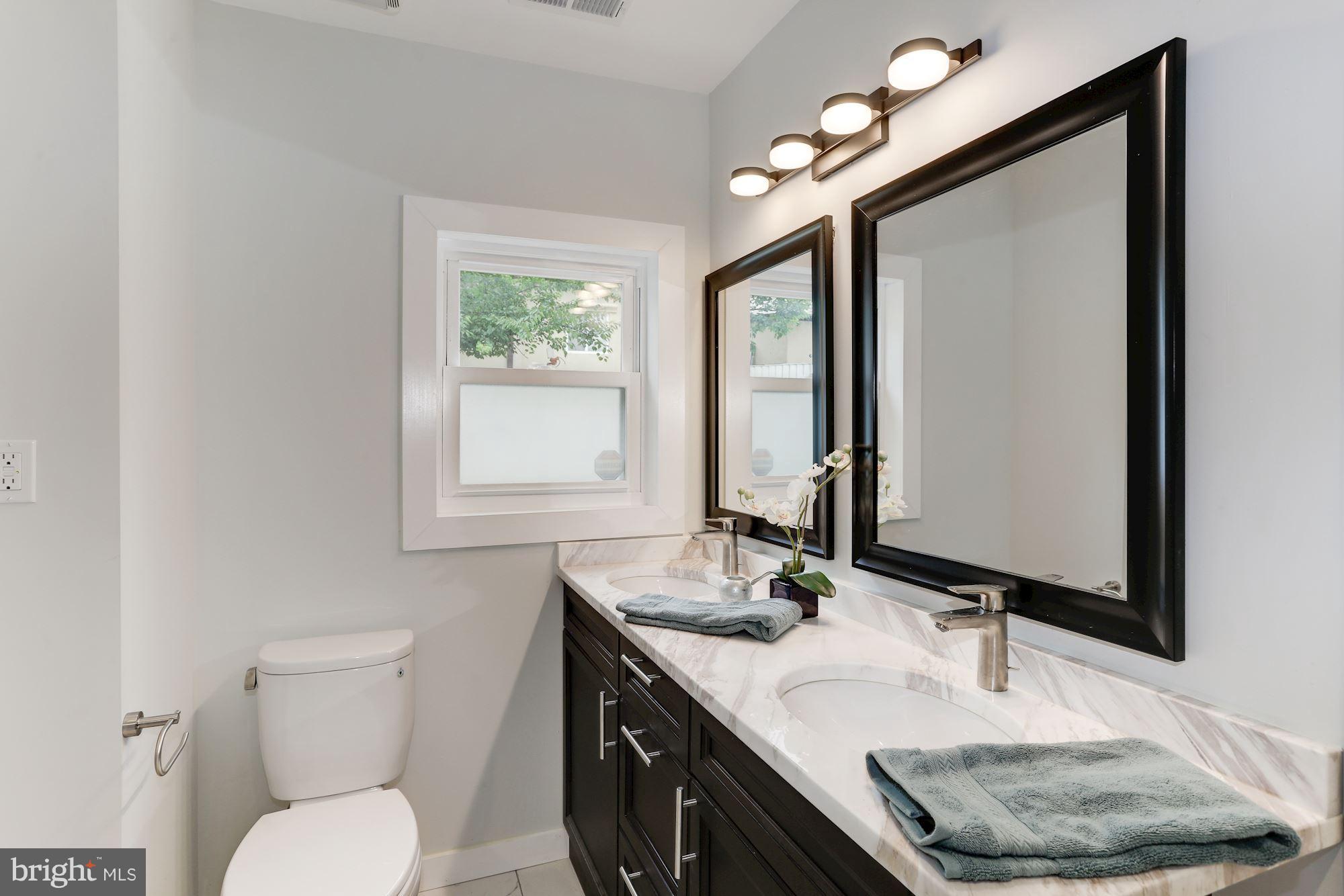 4303 Ivy Glen Road Silver Spring, MD 20906 - Photo 15 of 30 a bathroom with a granite countertop sink a toilet and mirror