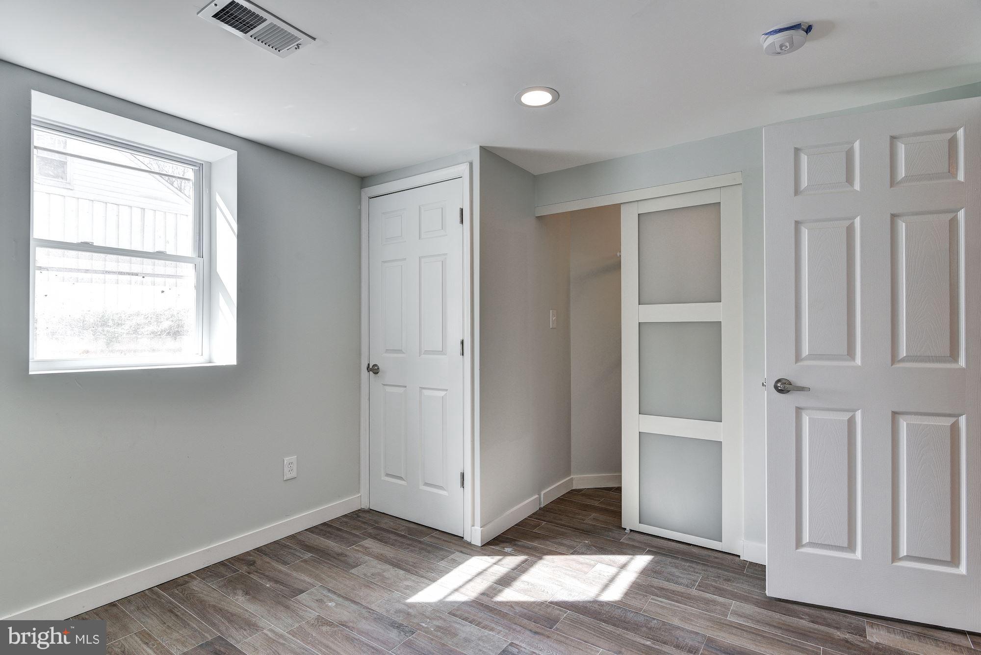 4303 Ivy Glen Road Silver Spring, MD 20906 - Photo 25 of 30 an empty room with wooden floor cabinet and windows