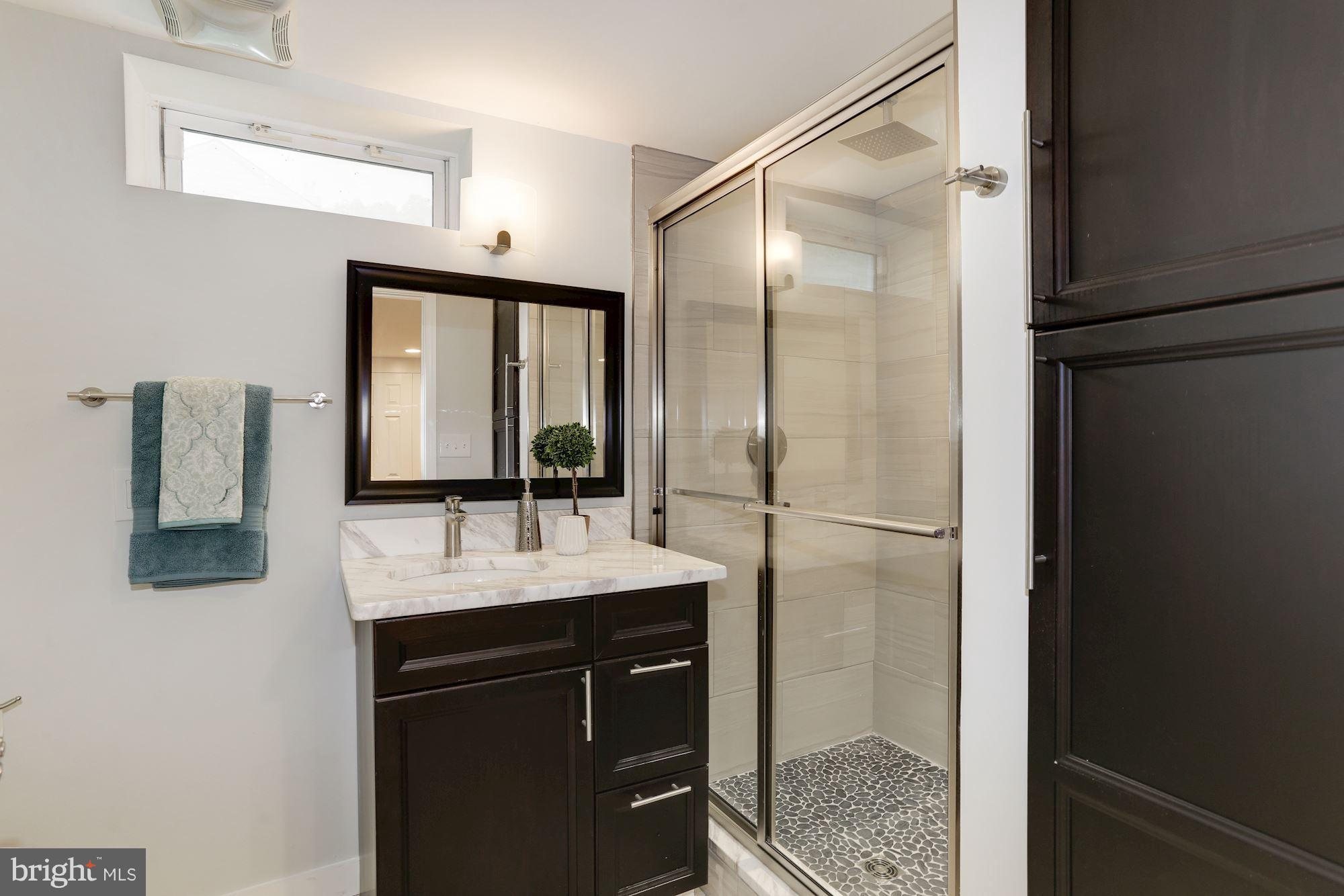 4303 Ivy Glen Road Silver Spring, MD 20906 - Photo 26 of 30 a bathroom with a shower sink and mirror