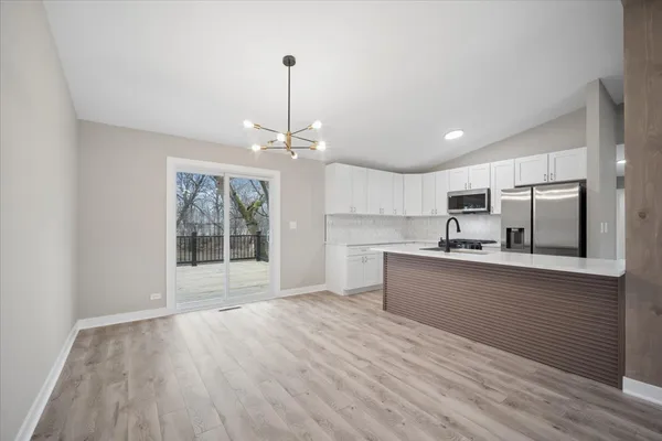 a large kitchen with cabinets wooden floor and stainless steel appliances