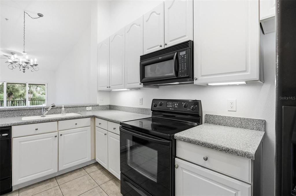 100 Canopy Walk Lane, Unit 133 Palm Coast, FL 32137 - Photo 7 of 51 a kitchen with white cabinets and appliances