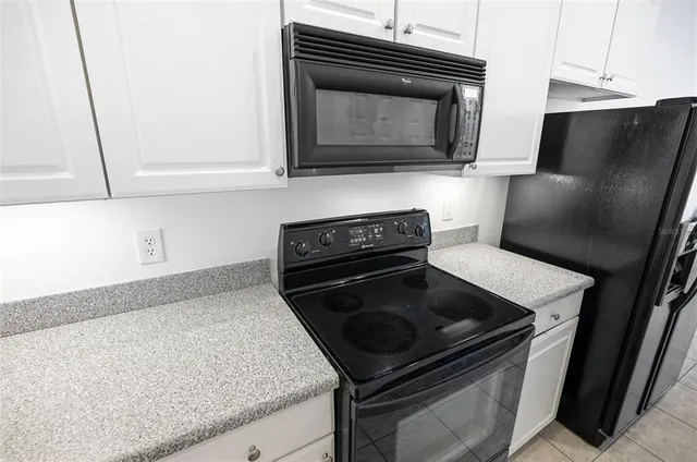 a kitchen with granite countertop stainless steel appliances and white cabinets