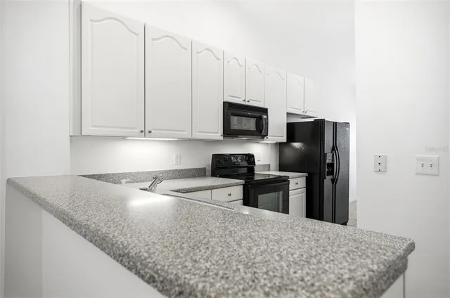 a kitchen with stainless steel appliances granite countertop a sink a stove and a refrigerator