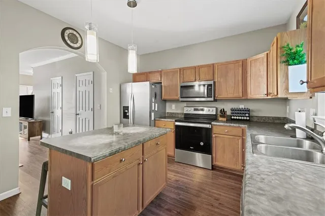 a kitchen with stainless steel appliances granite countertop a sink stove and refrigerator
