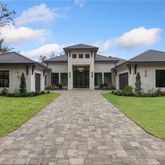 a front view of a house with a garden and plants