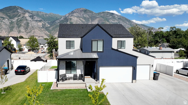 983 South 950 West Provo, UT 84601 - Photo 1 of 56 Contemporary two-story residence featuring a striking blue and white facade with black trim, a covered front porch, an attached two-car garage, and a concrete driveway