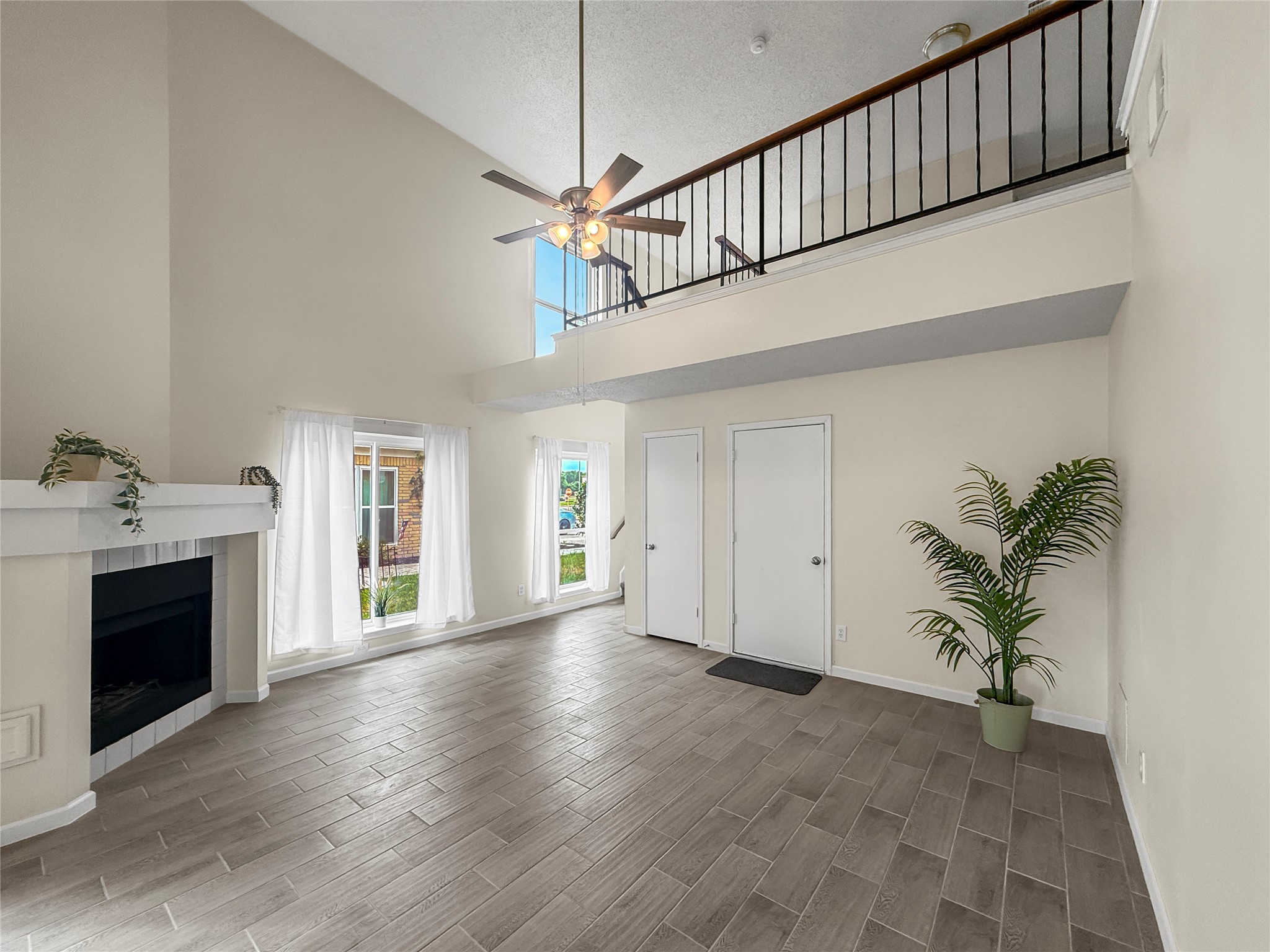 13635 Repa Lane Houston, TX 77014 - Photo 5 of 48 Coming home you enter a bright, open space. The lower area features a cozy living space with a fireplace, large windows, and high ceiling.