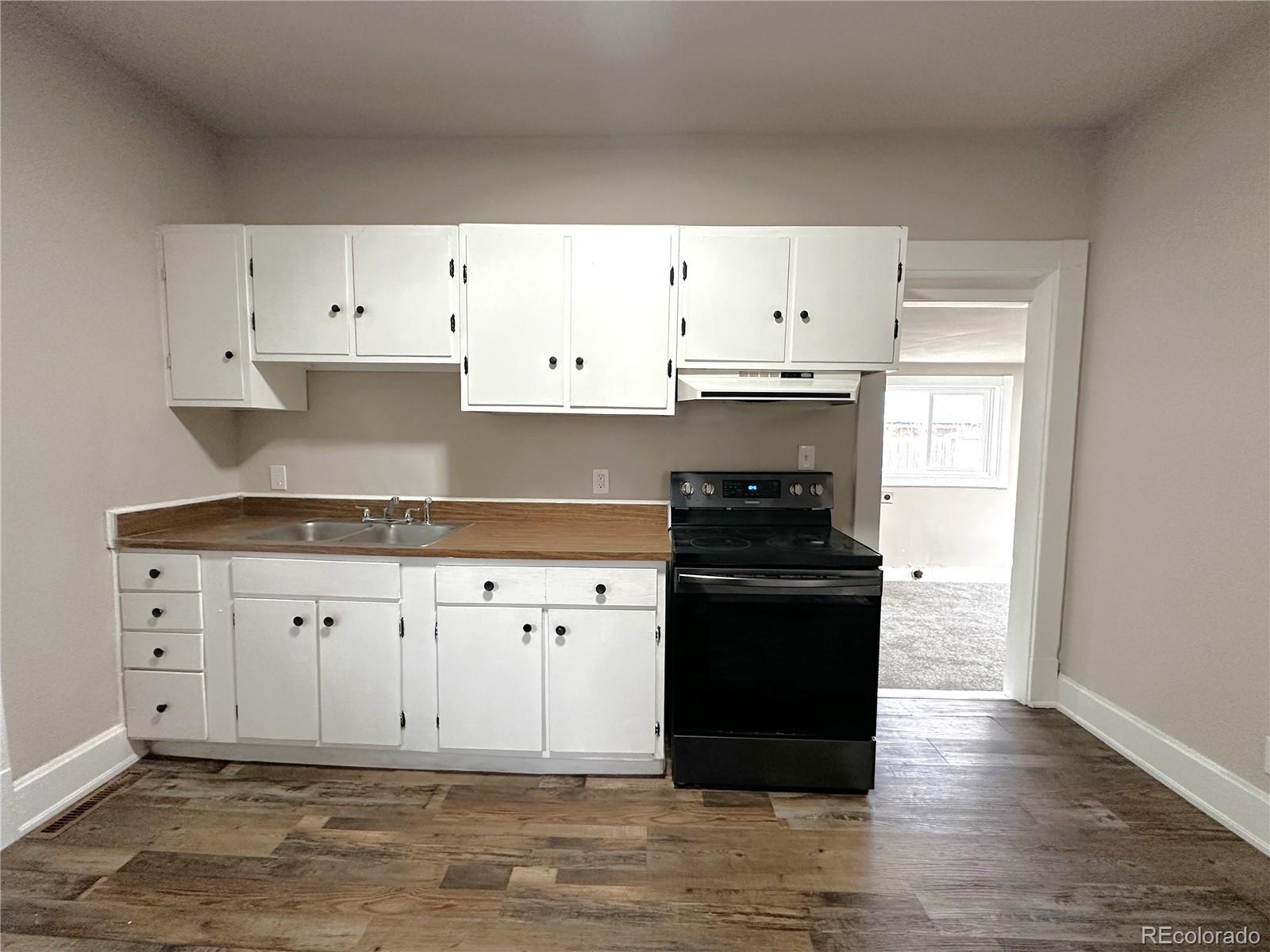 672 4th Street Limon, CO 80828 - Photo 14 of 28 a kitchen with granite countertop white cabinets and black appliances