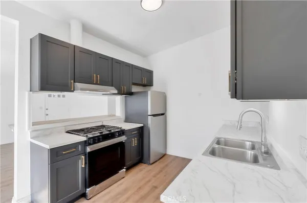a kitchen with stainless steel appliances a stove a sink and a microwave