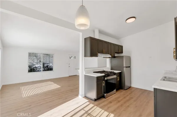 a kitchen with stainless steel appliances a stove a refrigerator and a sink