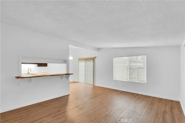 a view of a kitchen with wooden floor and a window