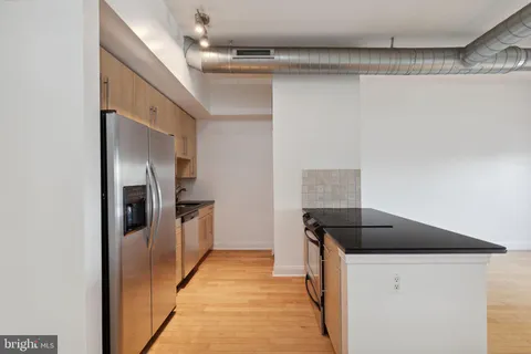 a hallway with cabinets and wooden floor