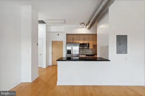 a large kitchen with stainless steel appliances a large counter top a stove and a refrigerator