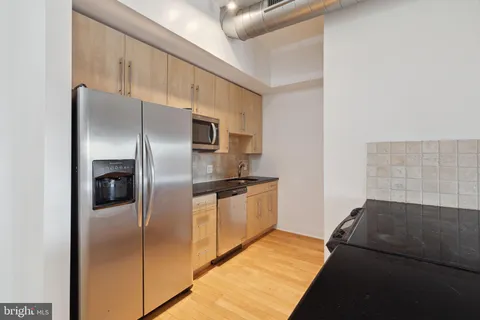 a kitchen with stainless steel appliances kitchen island a refrigerator sink and stove