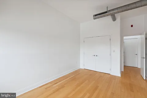 a view of empty room with wooden floor