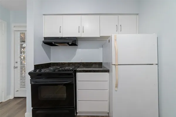 a kitchen with white cabinets and white appliances