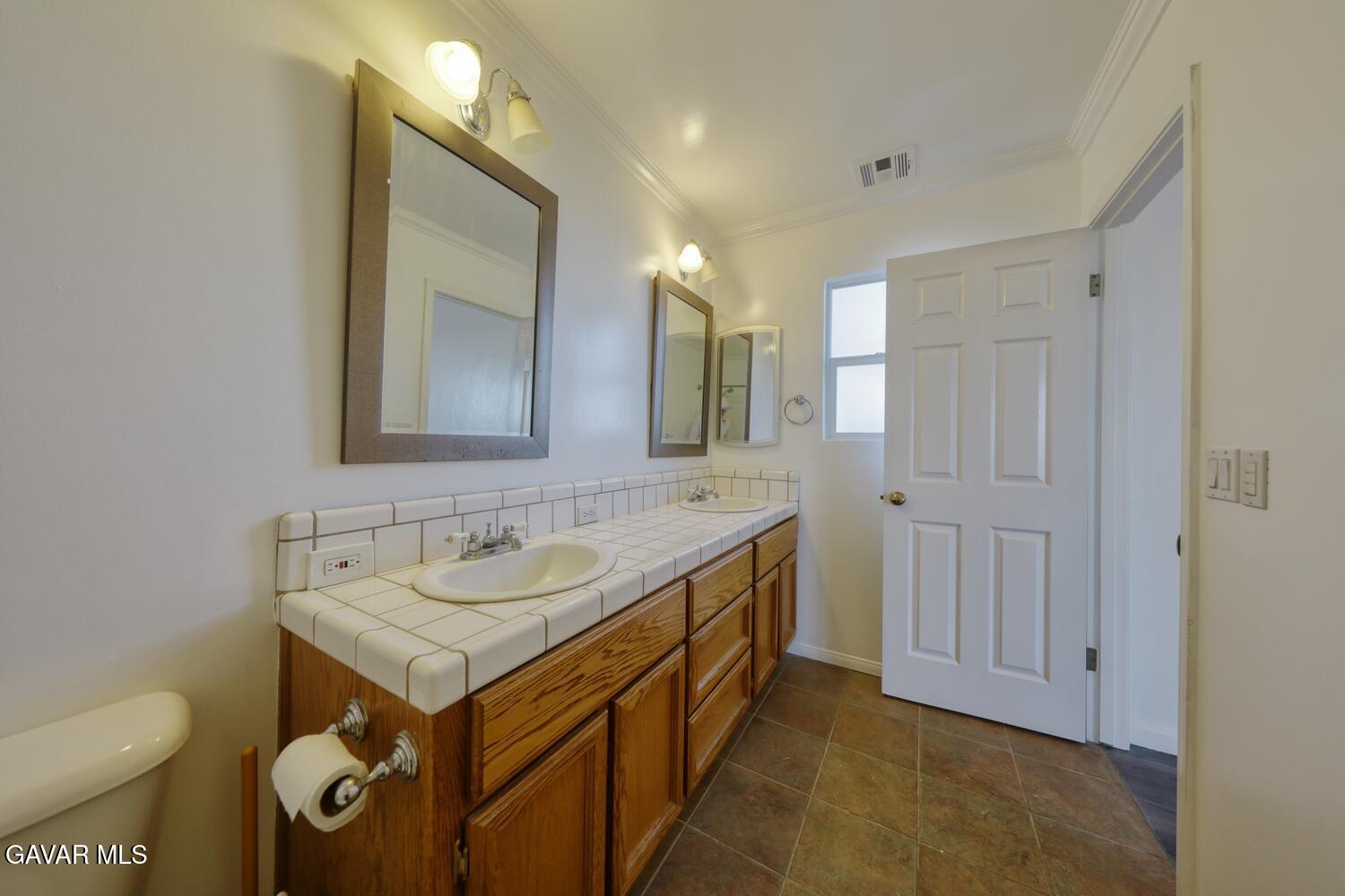 26801 Cabriolet Court Tehachapi, CA 93561 - Photo 28 of 60 a bathroom with a sink a toilet and a mirror