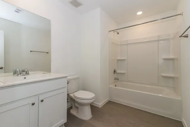 a bathroom with a toilet sink vanity and tub