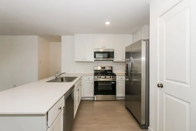 a kitchen with a refrigerator stove and sink