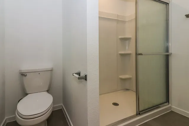 a bathroom with a toilet and a shower